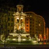A lit fountain at night in Lyon, France at night time