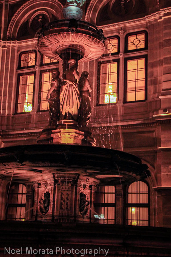 Lit fountain next to the Opera House of Vienna