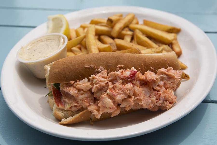 Lobster roll served with fries in Halifax, Canada. The dish is served with lemon and tartare sauce.