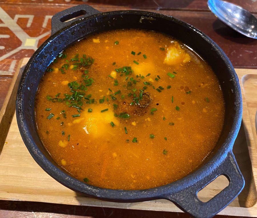 Classic Latvian sauerkraut soup with pork and fried potatoes